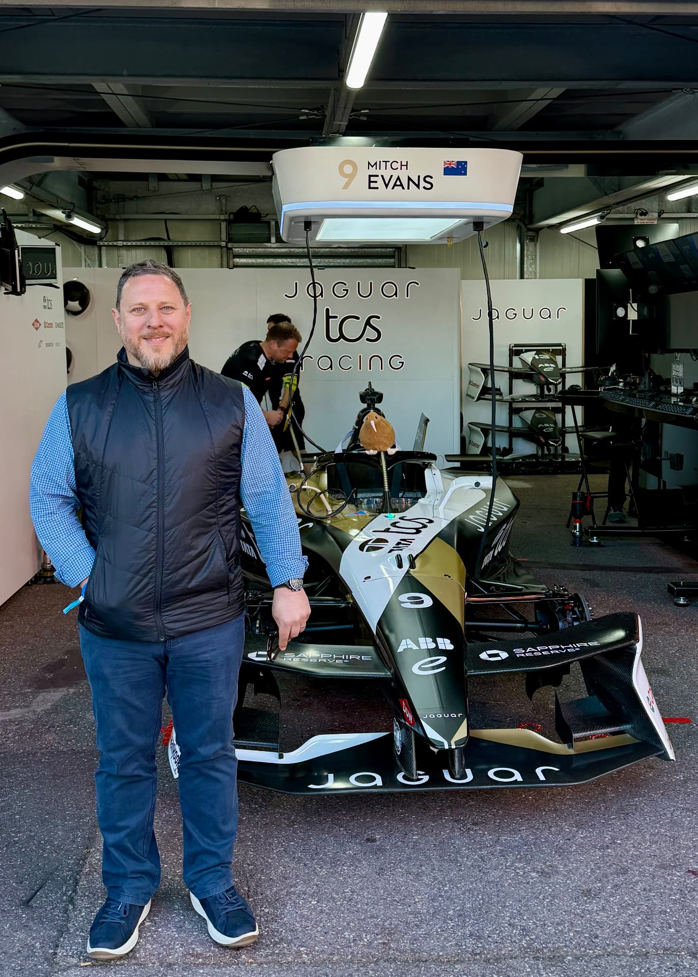 Russell McCann beside a Formula E team car